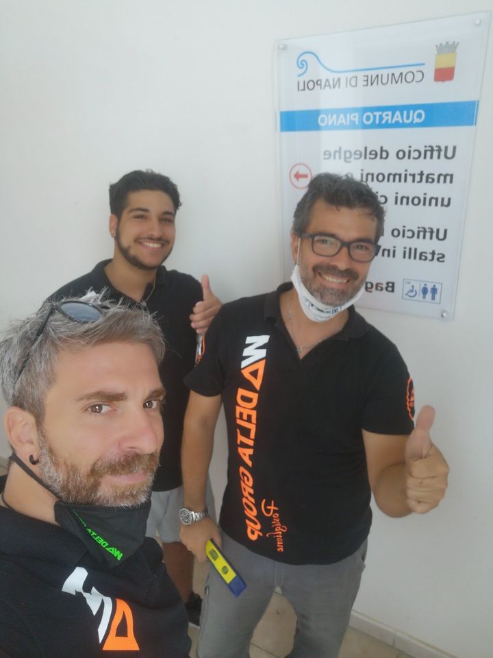 Tre uomini sorridenti si scattano un selfie al chiuso