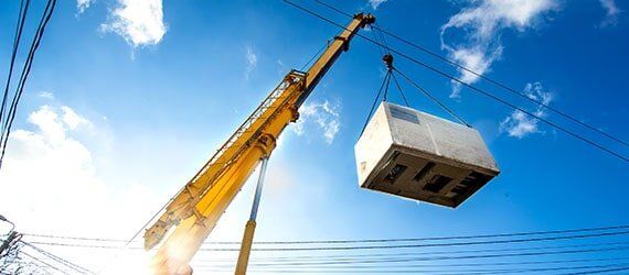 Yellow Crane Lifting a Container — Crane Service in Olive, MS Yellow Crane Lifting a Container — Crane Service in Olive, MS