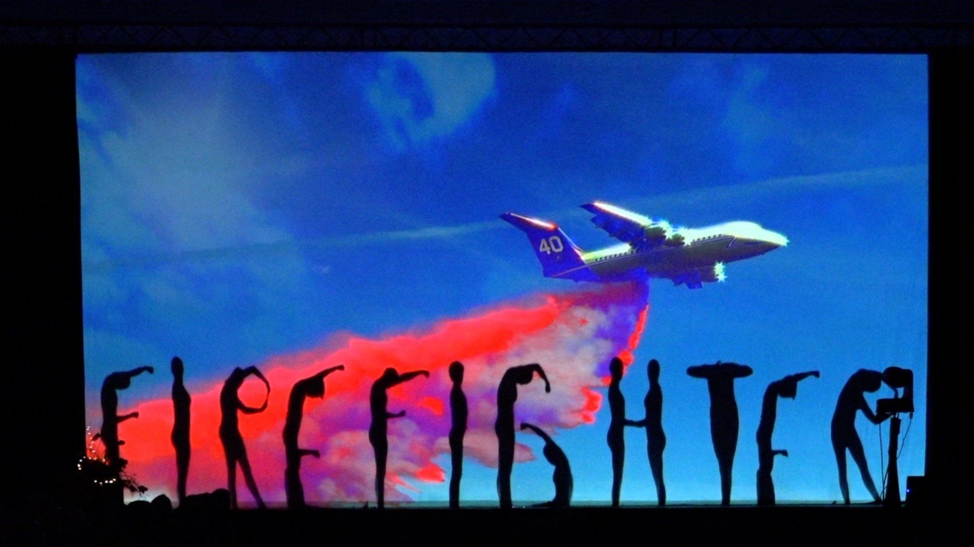 Airplane flying over a blue-red sky above stylized black text