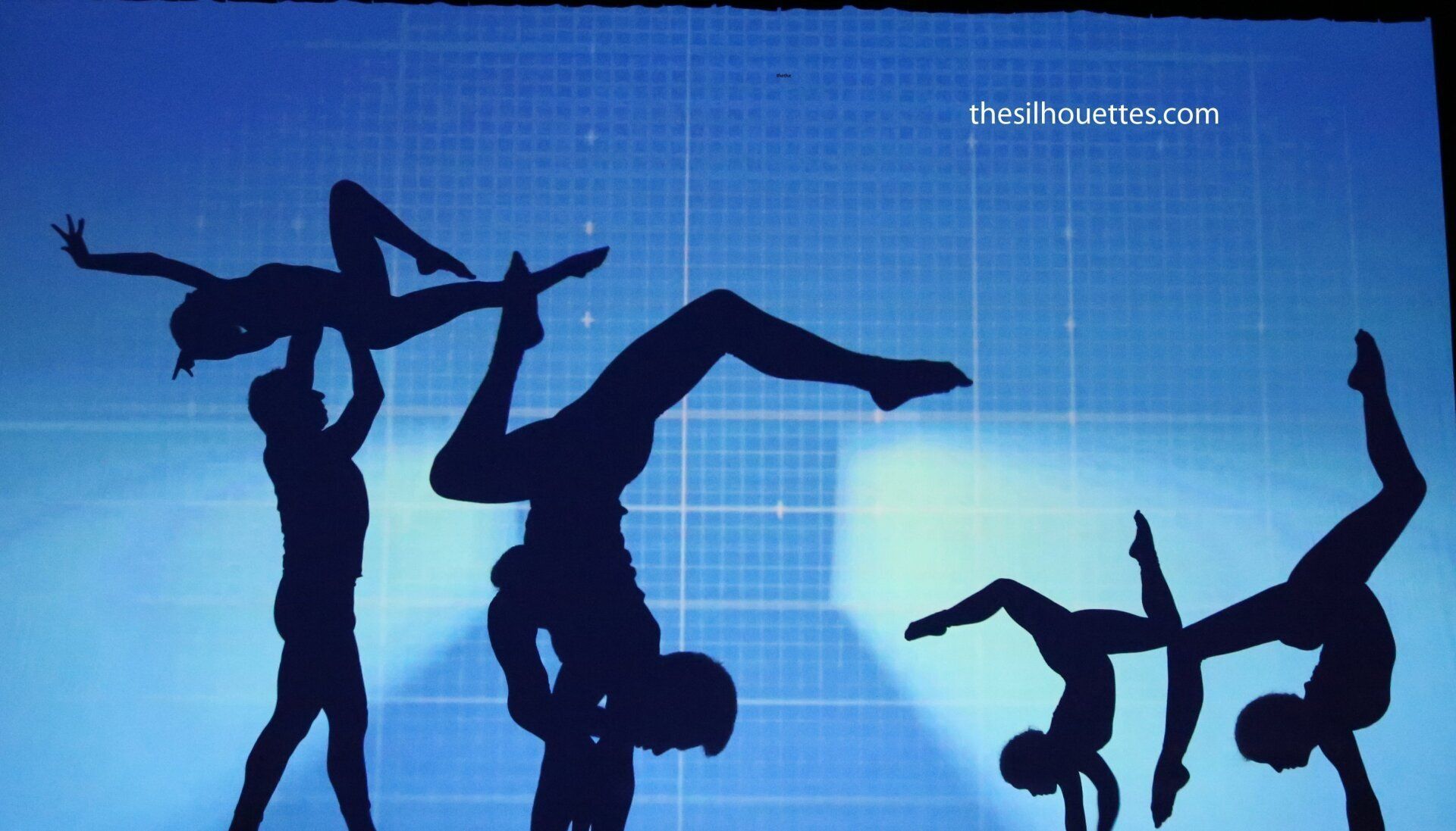 Silhouetted dancers posing against a blue background with a visible grid pattern