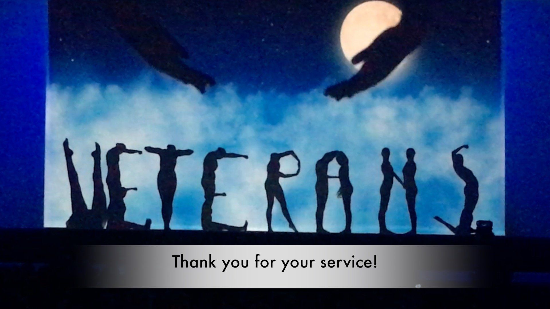 Blue poster reading “VETERANS” with “Thank you for your service!” below and raised hands above.