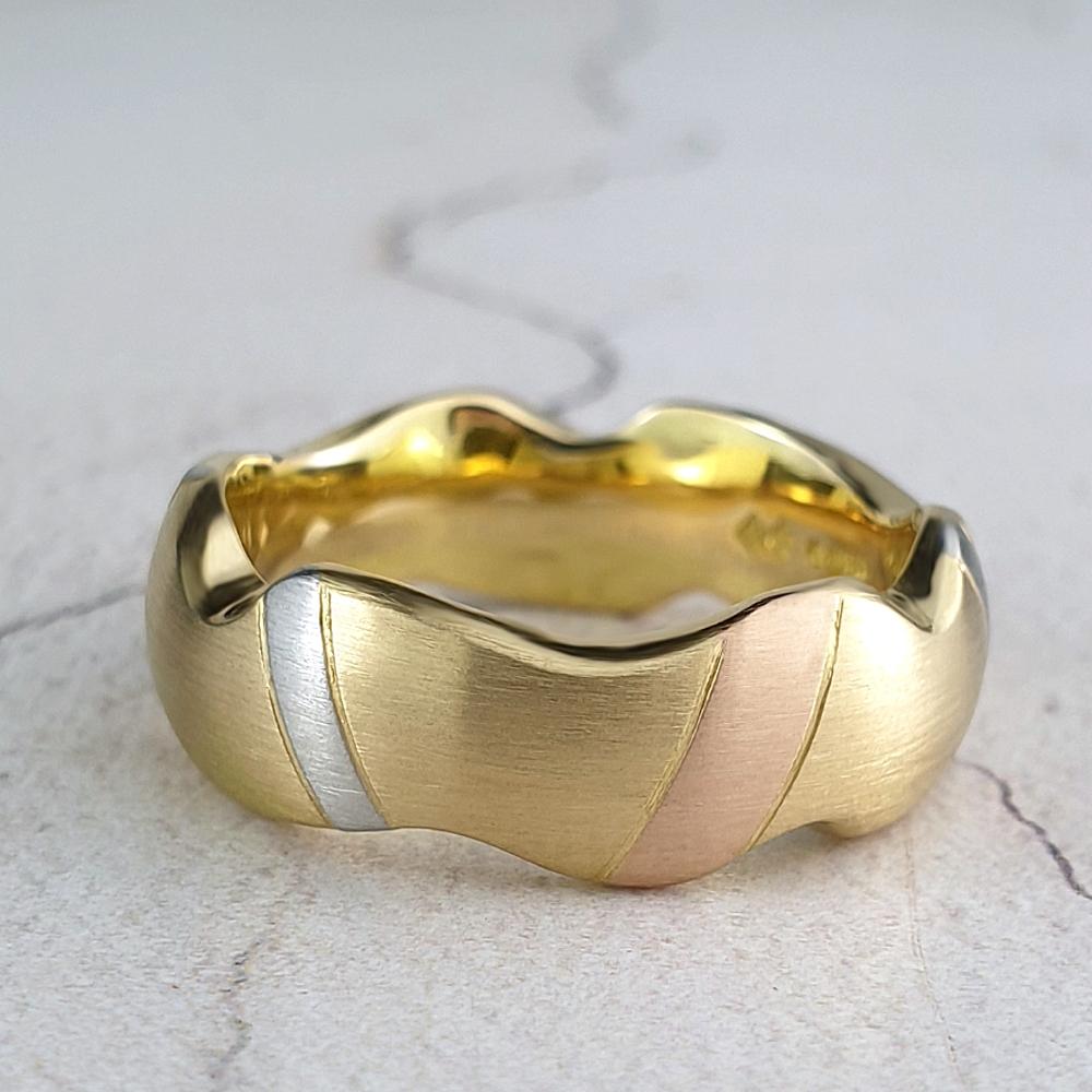 Carved yellow gold band with platinum and red gold stripes