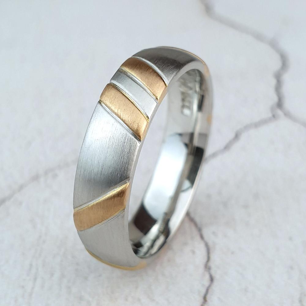 A man's platinum wedding ring inlaid with rose gold stripes