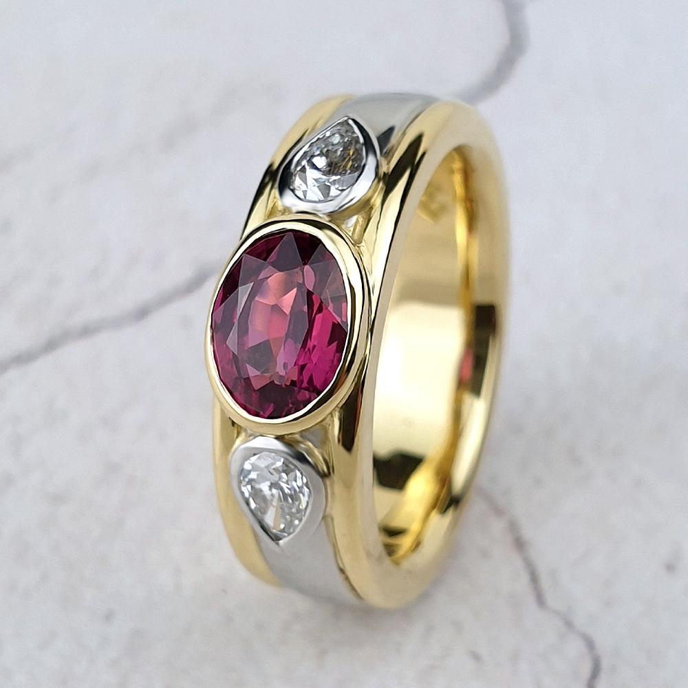 Oval ruby on a gold band with platinum centre