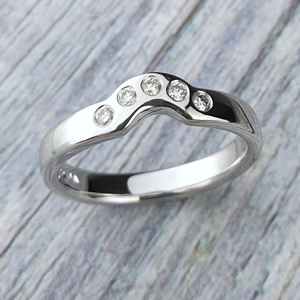 Platinum fitted band with an arc of five diamonds