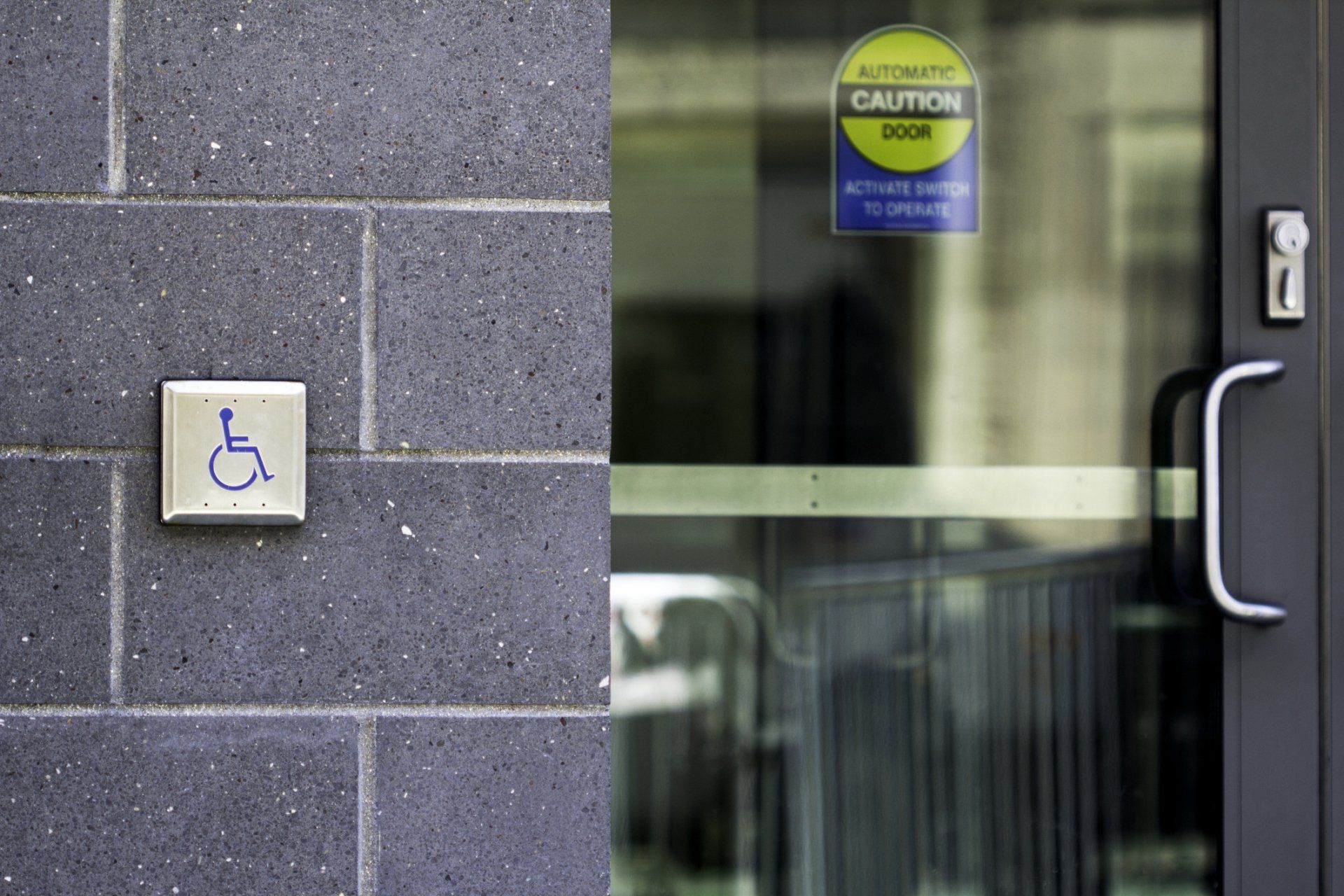 Accessible entrance with wheelchair sign and glass door handle