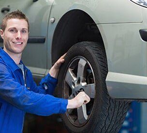 Man with Tire - Auto Repair in Glenmont NY Man with Tire - Auto Repair in Glenmont NY