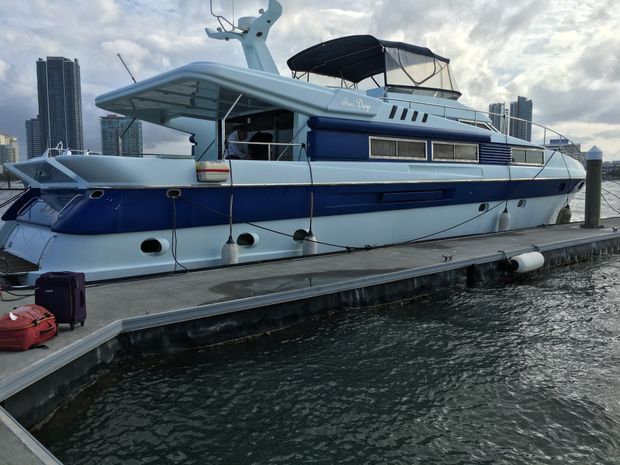 A blue and white boat is docked at a dock