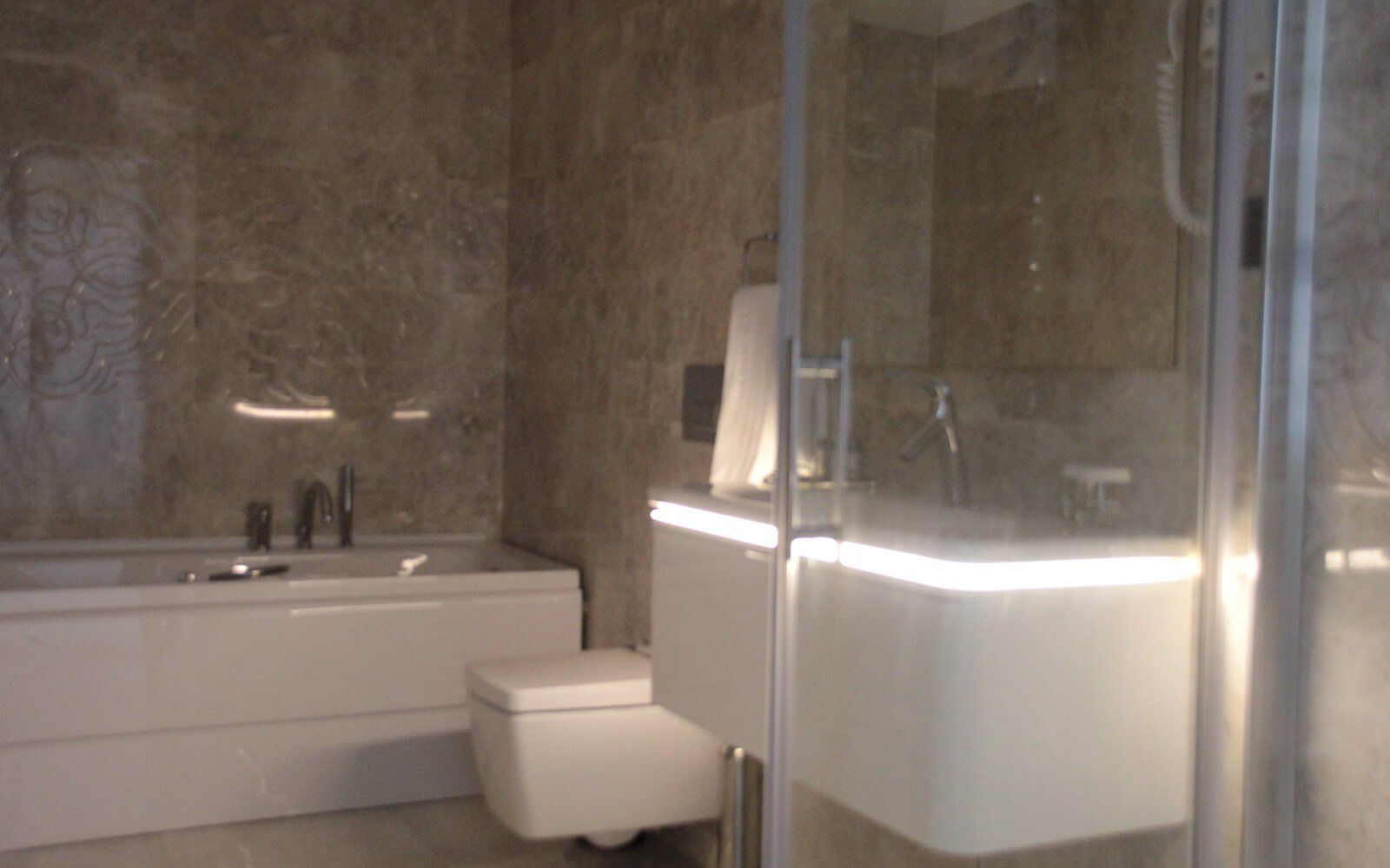 Küvet, tuvalet, lavabo ve duş içeren bir banyo.