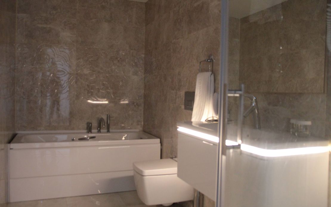 Küvet, tuvalet ve duş içeren bir banyo.