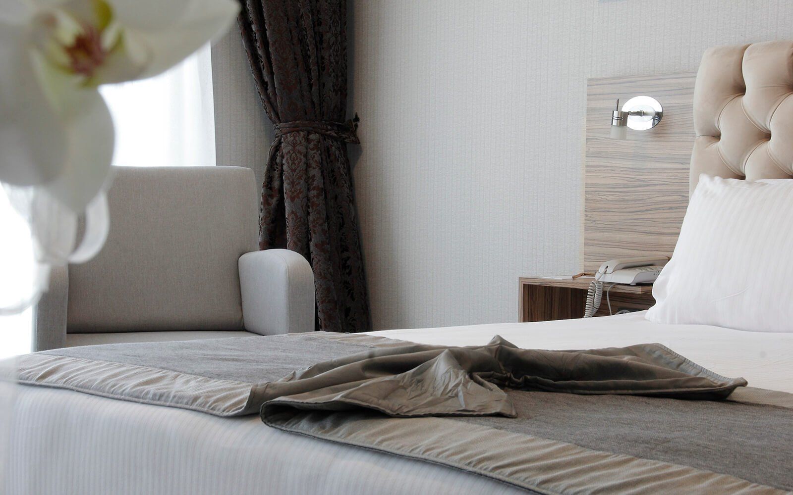 Bir yatak ve bir sandalyenin bulunduğu bir otel odası