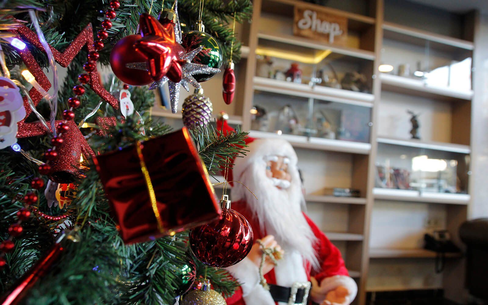 Noel Baba heykelciği bir Noel ağacının altında oturuyor.