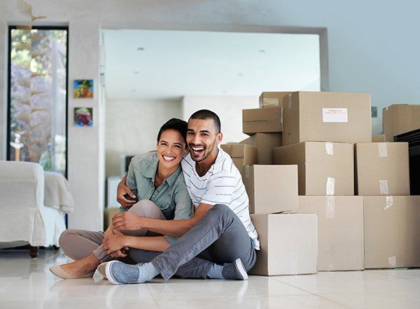 A smiling couple near moving boxes.