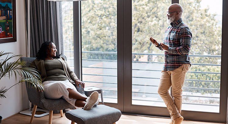 A man and a woman are standing next to each other in a living room.