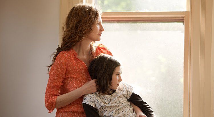 A woman and a child are looking out of a window.
