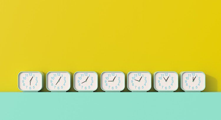 The clocks are lined up in a row on a yellow and blue background.