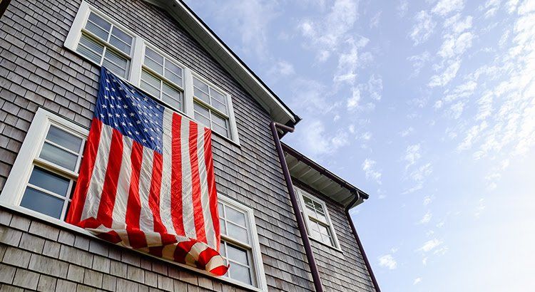 An american flag is hanging from the side of a building.