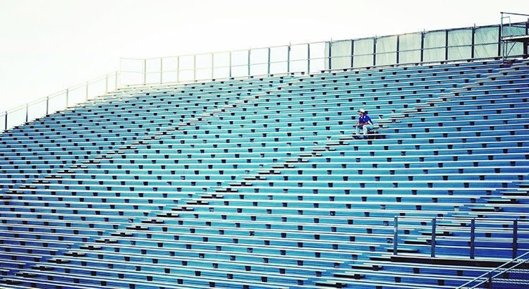 A person is standing in the stands of a stadium.