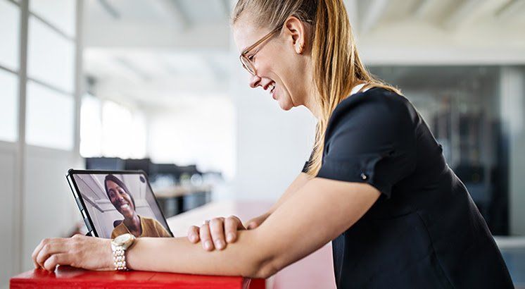 A woman is sitting at a desk using a laptop computer.