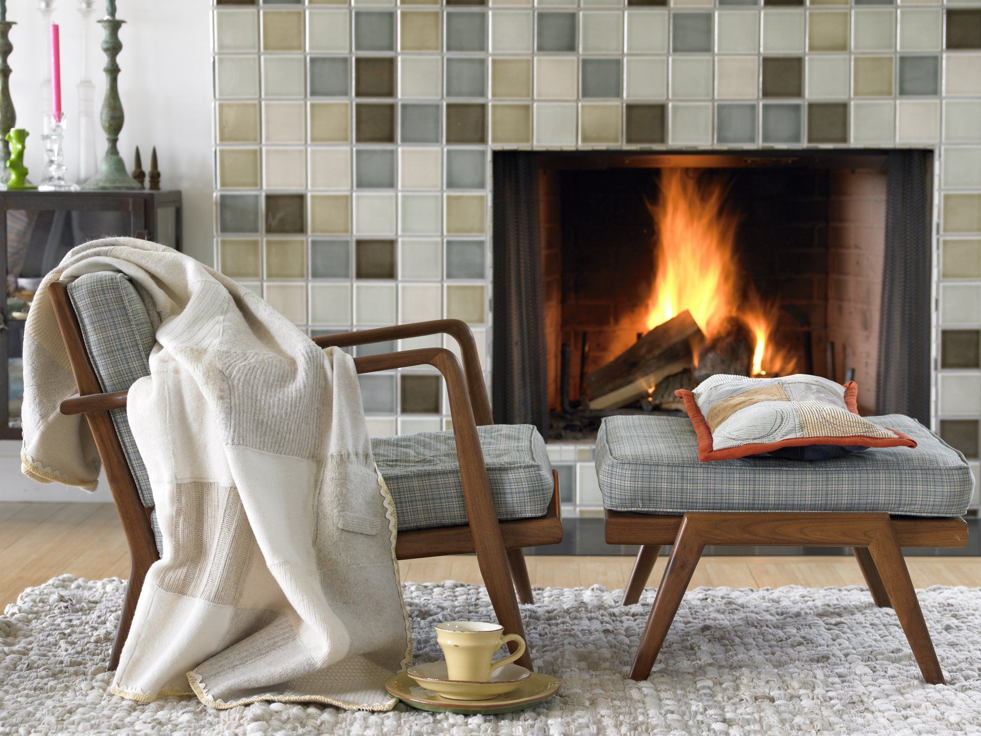 Burning fireplace in the living room with two chairs in front