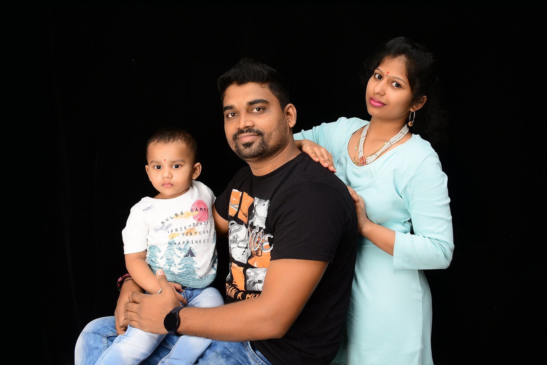 A man and a woman are posing for a picture with a baby.