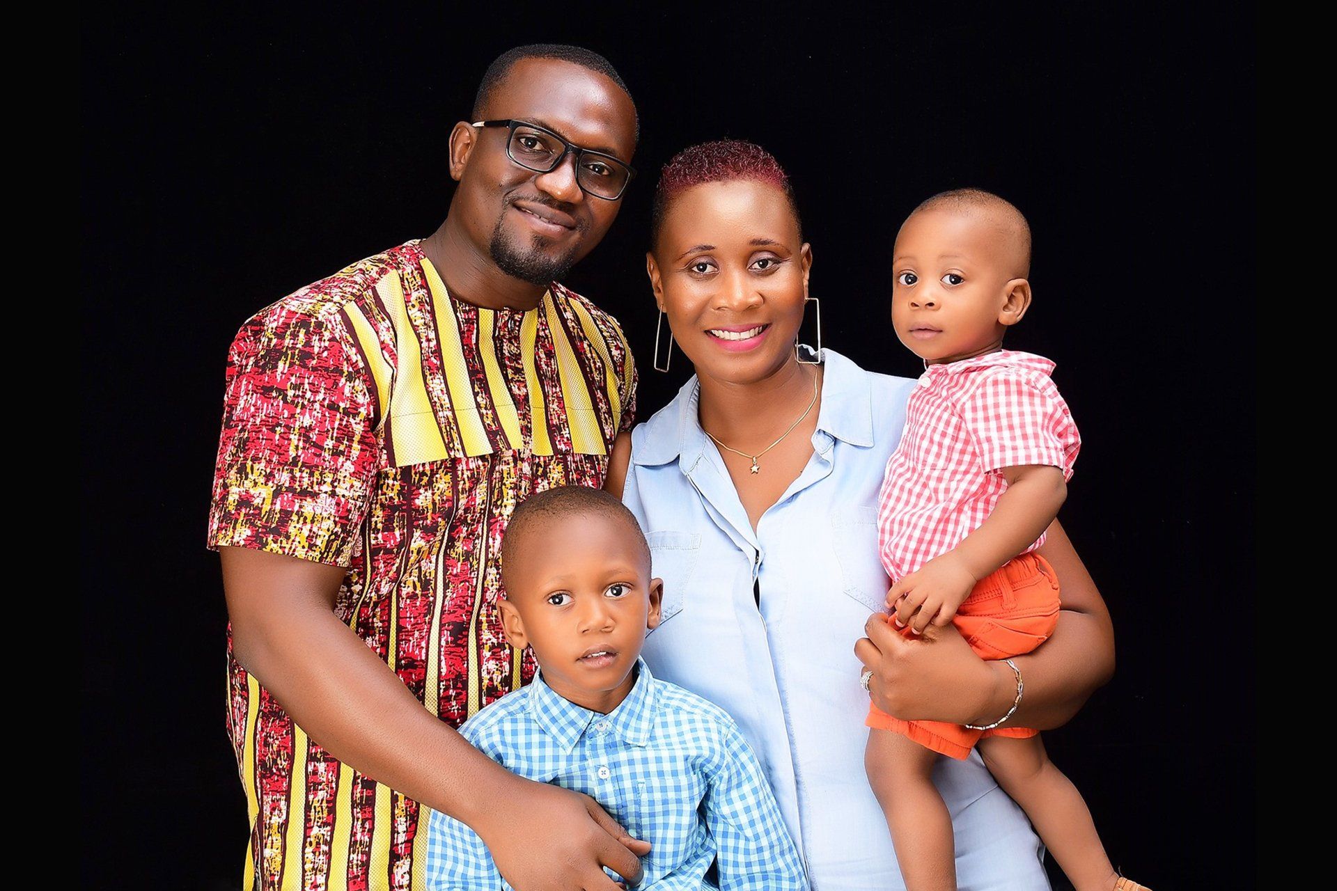 A man and woman are posing for a picture with two children.
