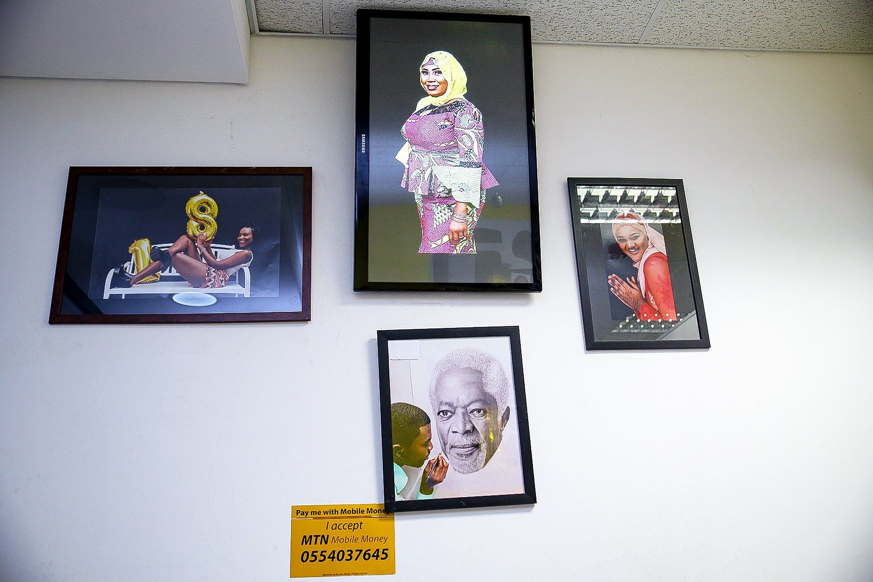 Several framed pictures on a wall including one of nelson mandela