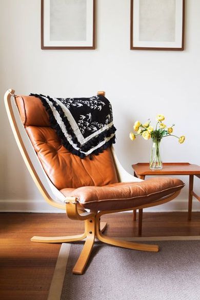 Vintage retro tan leather danish chair and table with vase of flowers