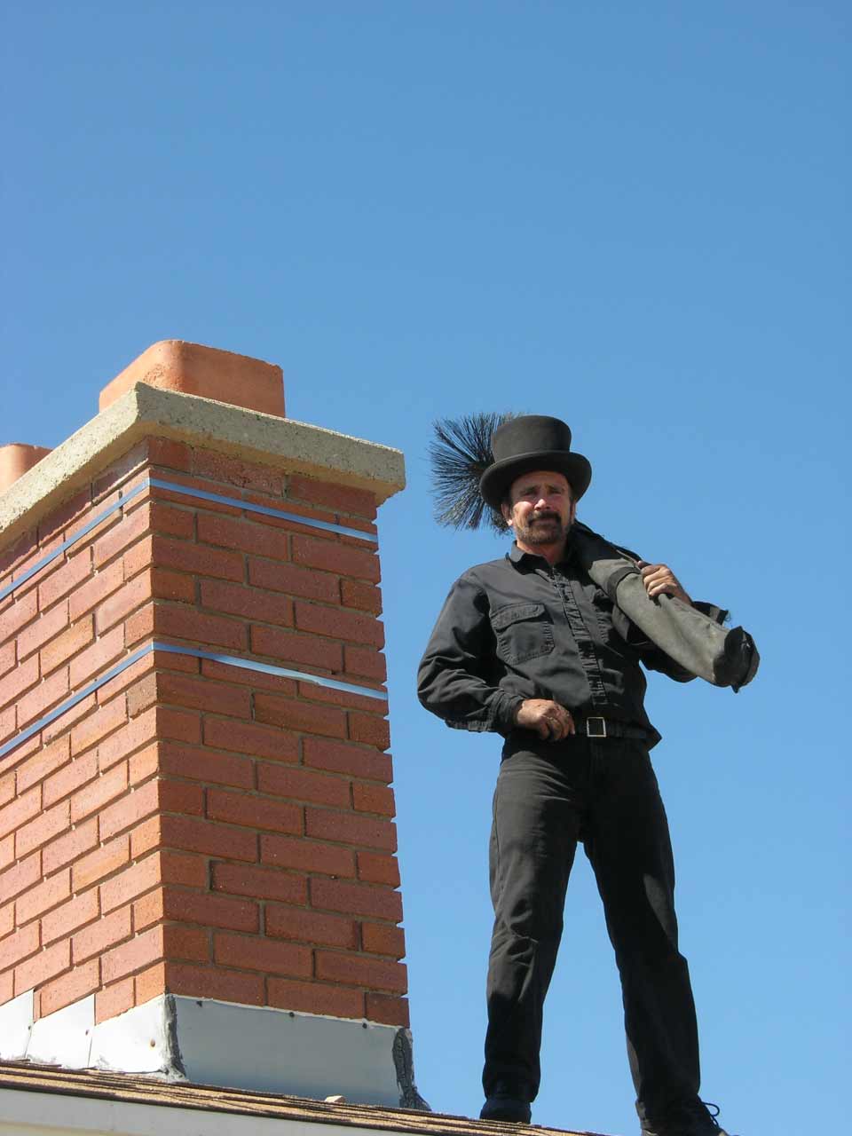 Chimney Flue Cleaning — A Man Standing on the Rooftop in Wasatch Front, UT Chimney Flue Cleaning — A Man Standing on the Rooftop in Wasatch Front, UT