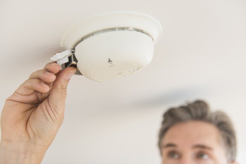 Smoke detector installation. Engineer checks battery