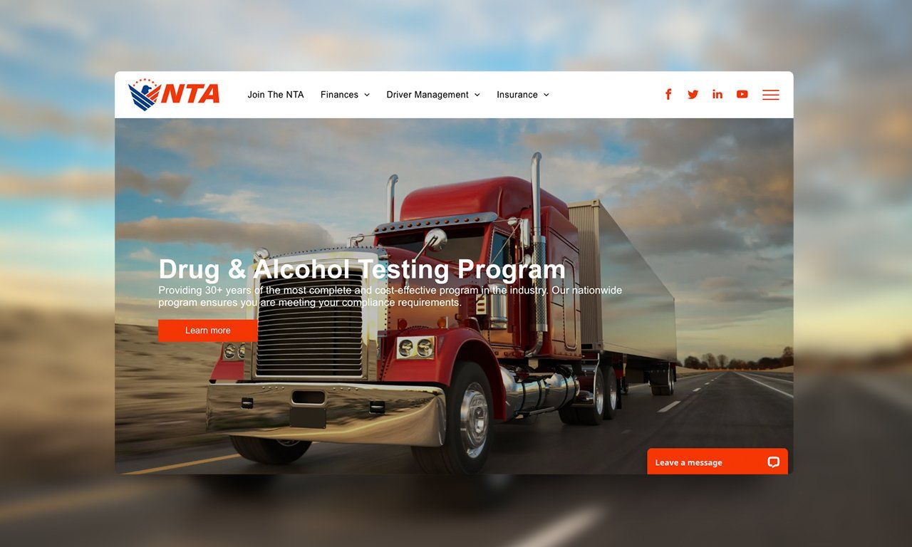 A red semi truck is driving down a highway on a website.