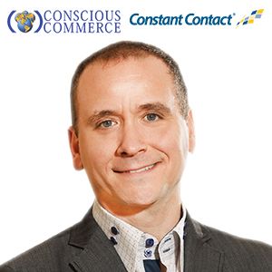 A man in a suit is smiling in front of a constant contact logo