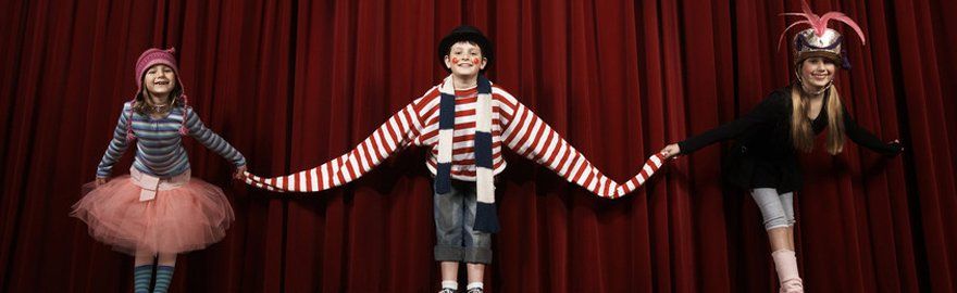 Three children in costume, taking a curtain call