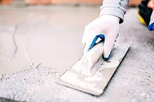Worker laying cement — Chimney Cleaning in Kern County, CA Worker laying cement — Chimney Cleaning in Kern County, CA