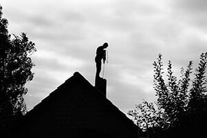Chimney sweeper working on the roof — Dryer Vent Cleaning in  Kern County, CA