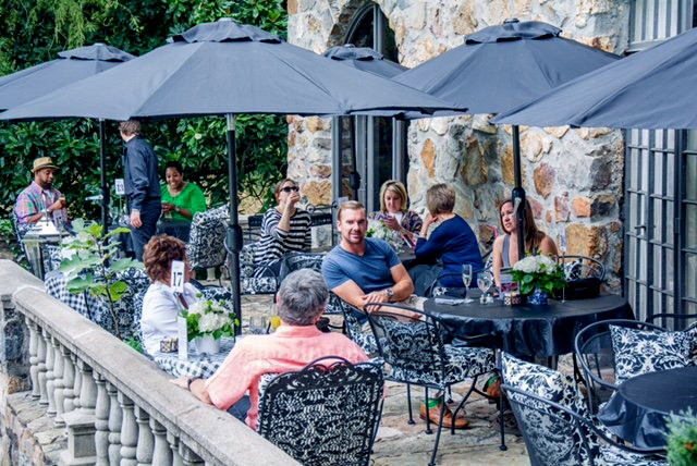 Wedding reception area with people sitting down under umbrellas at a castle in little rock arkansas