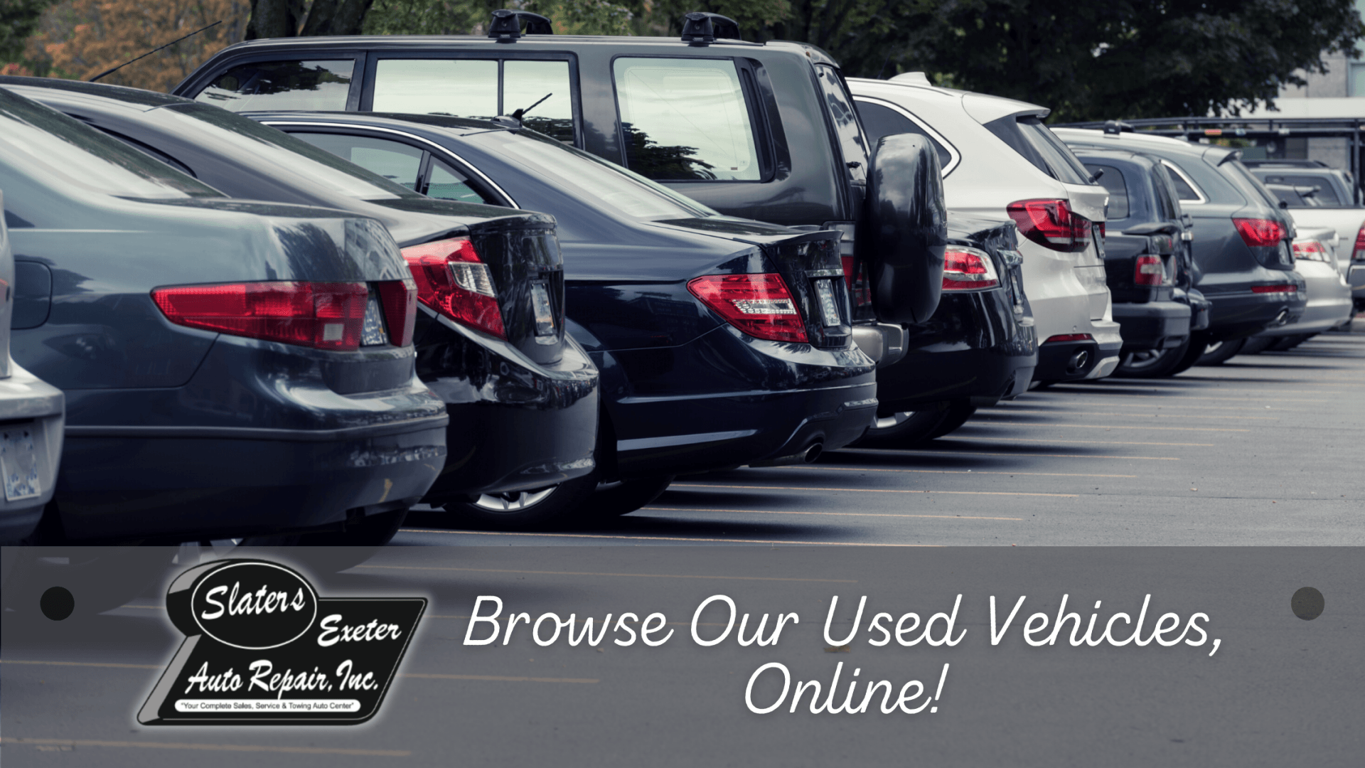 Row of parked used cars with sign reading “Browse Our Used Vehicles Online!”