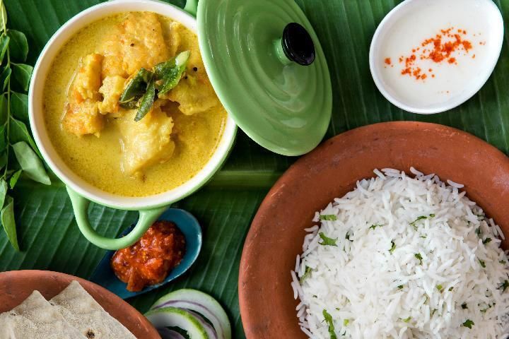 A bowl of soup and a bowl of rice are on a table.