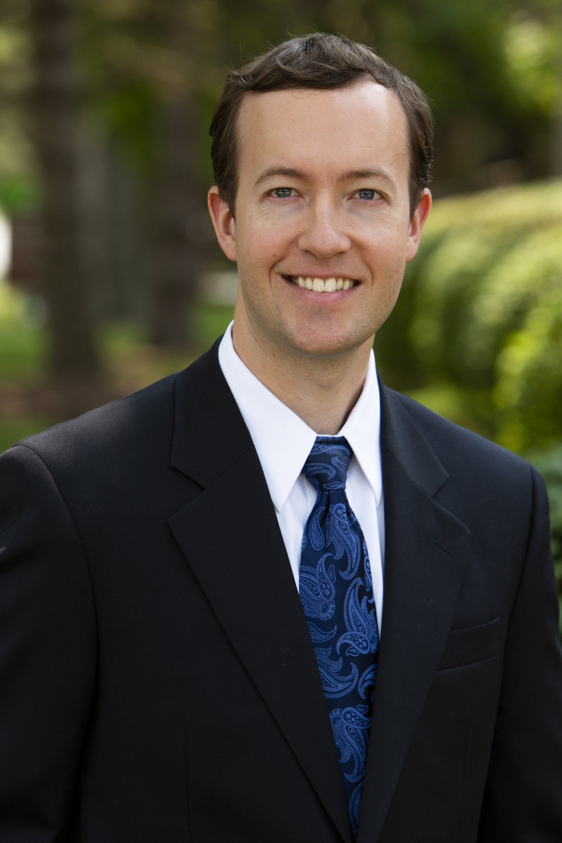 A man in a suit and tie is smiling for the camera.
