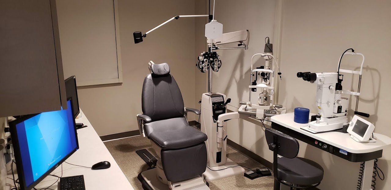 An ophthalmologist 's office with a chair and a computer.