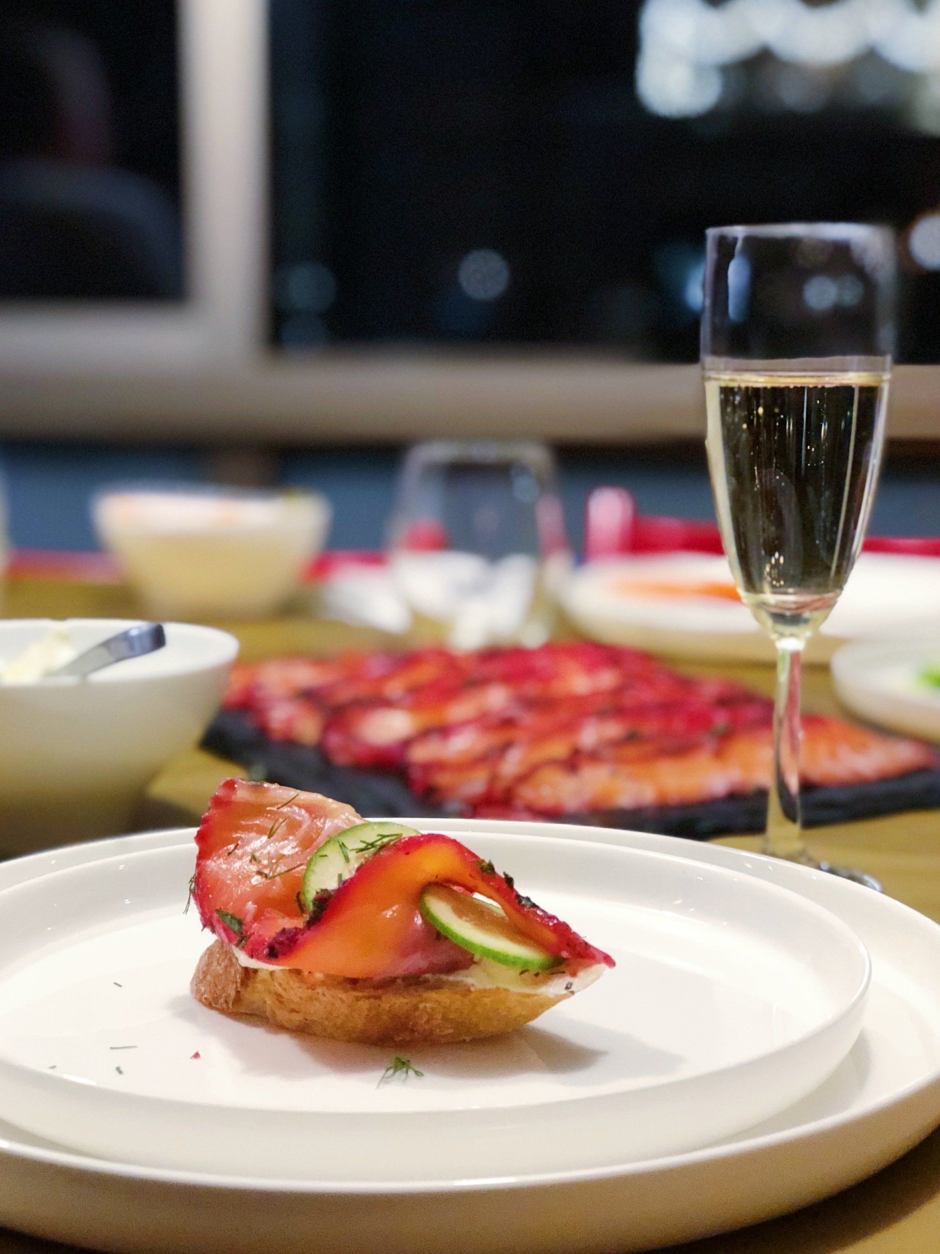 Wine glass beside plated cured salmon appetizer for a private event