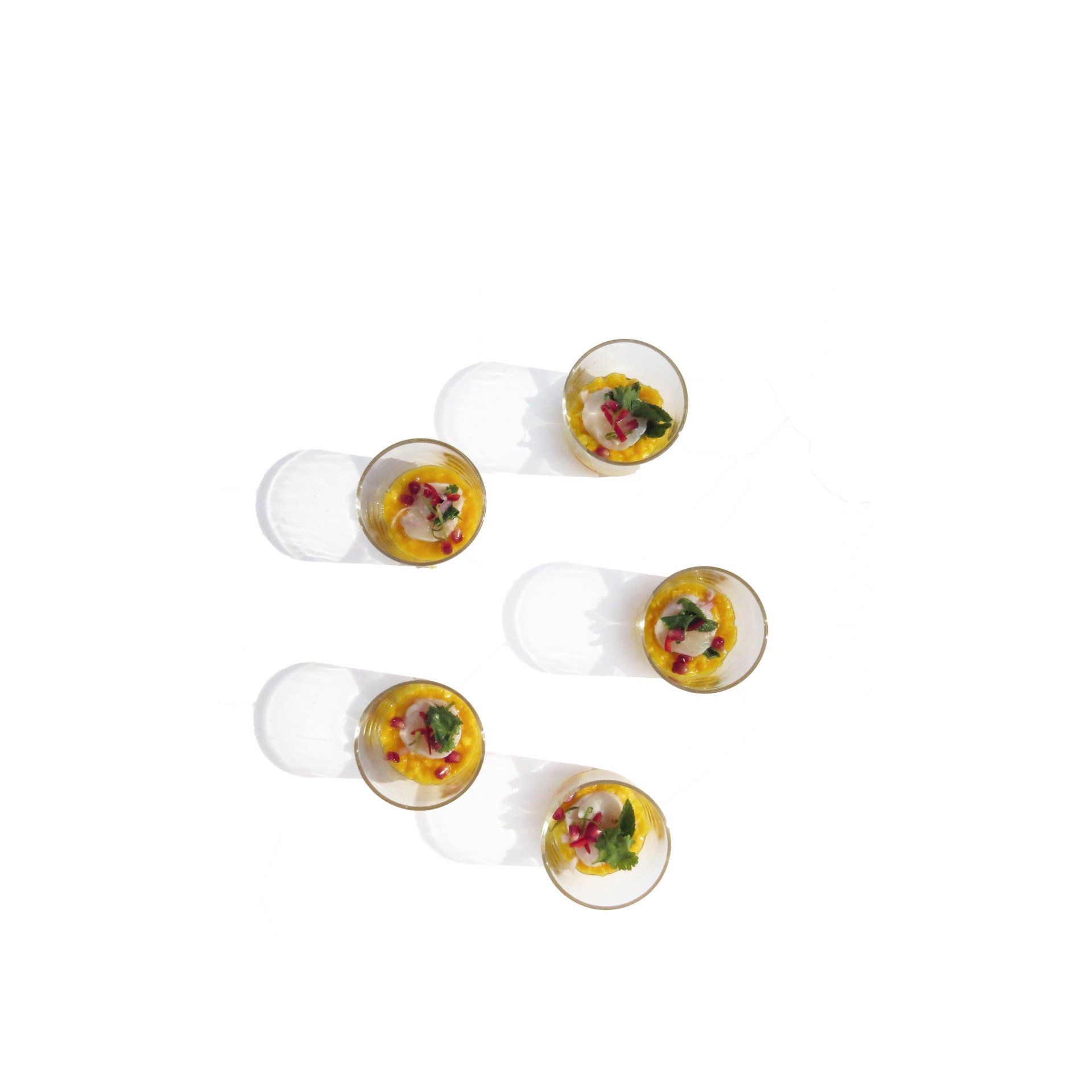 Five clear round glasses with a Mediterranean appetizer