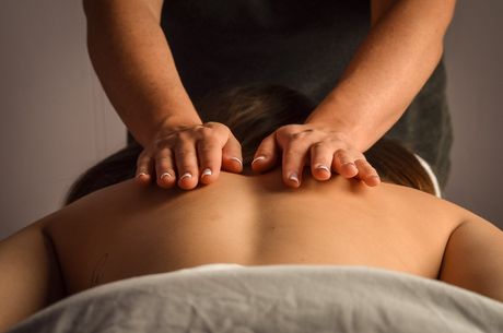A woman is getting a massage with her hands on her back.