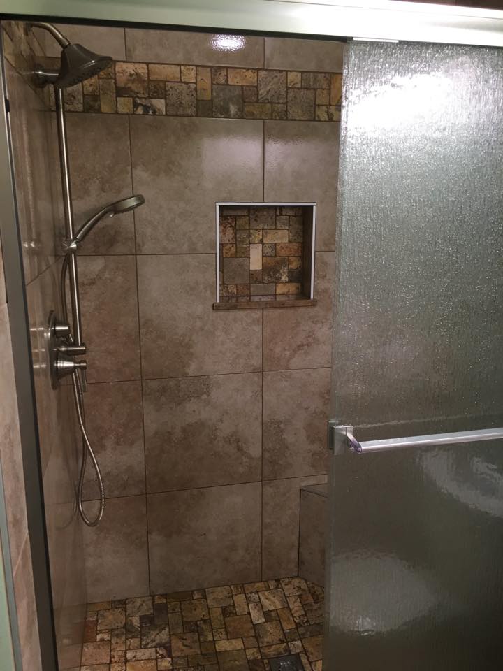 The image shows a walk-in shower with a glass door. The image shows a walk-in shower with a glass door.