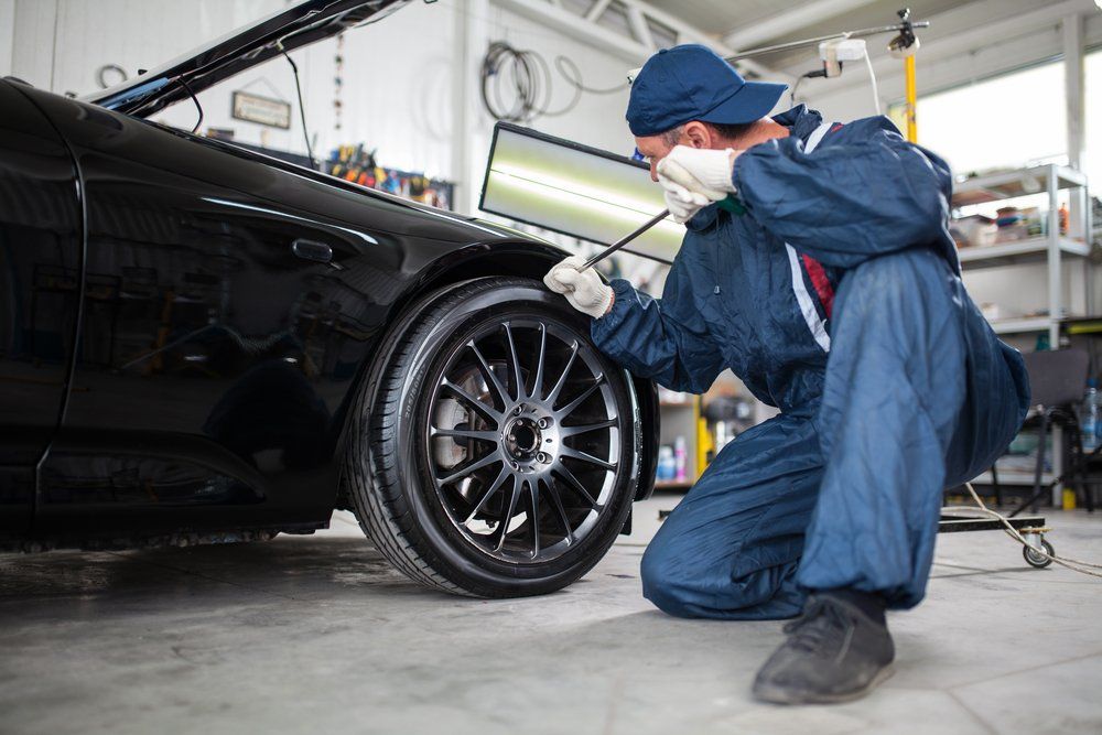 Mechanic Fixing Car's Wheel — Noosa Mechanical in Noosaville, QLD