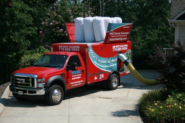 A red truck is parked in the driveway of a house