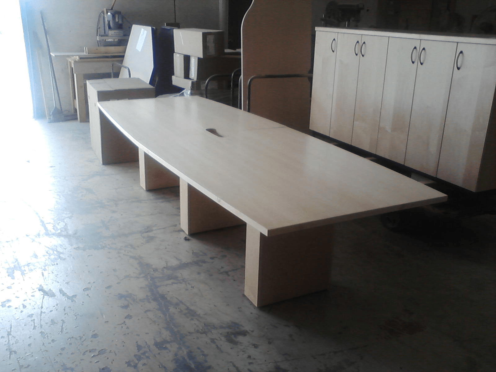 Light wood conference table in a workshop setting.