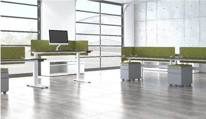 Modern office with height-adjustable desks, green cubicle dividers, and gray rolling storage bins. Bright interior.