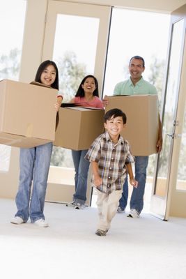 Family with boxes moving into new home smiling