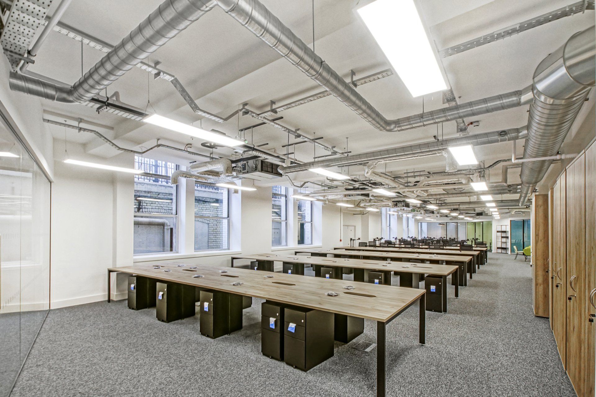 A large empty office with a lot of tables and chairs.
